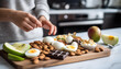 © Made - Healthy snack board with hard boiled eggs, almonds, Greek yogurt, apple slices, and dark chocolate square, fitness style layout