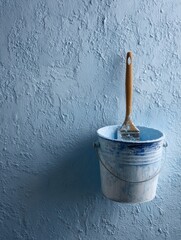 Poster - Primer Paint Bucket and Brush on Textured Wall During Home Renovation Project