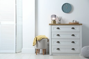 Poster - Dresser with stylish reed diffuser and lamp near white wall indoors
