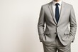 © Pixels Hunter - Confident businessman in gray suit with hands in pockets posing against light background for professional business concept shot.