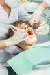 © timltv - Teenager undergoes dental procedures in a bright clinic with professionals attending to oral health needs