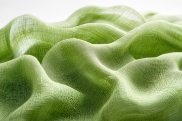 Poster - Soft green fabric draping elegantly on a surface, showcasing texture and light play during daytime, highlighting the beauty of natural fibers