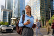 © Valerii Apetroaiei - Confident young businesswoman crossing busy city street with coffee and smartphone