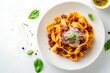 © designitsme - Delicious pappardelle bolognese pasta recipe with basil and parmesan cheese on a white plate