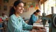 © Viktor - Smiling Indian woman works on sewing machine. Female tailor at work in workshop, creating clothes. Handmade production, garment industry. Positive expression, small business in village, dressmaking