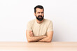 © luismolinero - Caucasian man with beard in a table with unhappy expression.