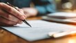© Wararat - Close-up of hands reviewing family legal documents on wooden desk, pen and checklist beside, trust-building professional environment