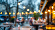 © miracle - A blurred background of an outdoor cafe with people sitting at tables