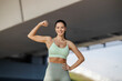© Dusan Petkovic - Portrait of muscular strong sportswoman standing on city street downtown and flexing muscles while smiling at the camera.