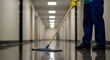 © Ahmdfadhilah - Professional cleaning service worker mopping floor in long hallway for hygiene maintenance