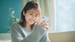 © Aruzimakon - 自宅でスマートフォンを使う笑顔の女性 #02