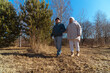 © looking2thesky - Romantic and elderly healthy lifestyle concept. Senior active Caucasian couple holding hands looks happy in park in autumn forest,happy anniversary,happily retired married couple together