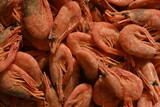 Fresh boiled shrimps stacked together on a seafood market. Close-up texture of orange crustaceans — symbol of gourmet cuisine, fishing harvest, and marine food industry.