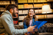 © Mediteraneo - Two Students Studying and Reading from Folder in Library