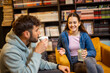 © Mediteraneo - Smiling Friends Enjoying Coffee and Conversation at Library Café
