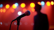 © Curioso.Photography - Microphone in focus with blurred performer on stage and colorful concert lights in the background.