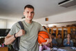© Miljan Živković - handsome man student stand with backpack and basket ball in library