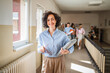 © Miljan Živković - mature female teacher walk confidently at school hallway with handbag