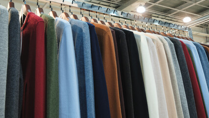 Poster - A rack of clothes with a variety of colors and styles. The clothes are hanging on a rack, and the colors include red, blue, green, and white