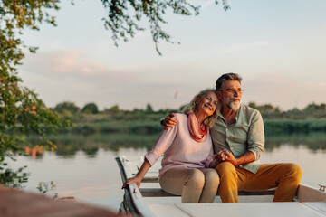 senior couple enjoying a peaceful sunset boat ride on a lake