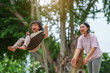 © geargodz - cheerful toddler girl with mother playing on a swing at playground