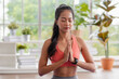 © weedezign - young healthy asian woman practice yoga on a mat at home in a yoga sitting position