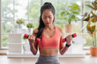 © weedezign - young healthy asian woman weight training dumbbell at home