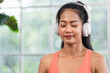 © weedezign - young healthy asian woman listening music while practice yoga at home