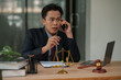 © aekachai - Male lawyer using phone to talk to client and give legal advice