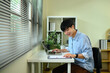 © Prathankarnpap - Happy male entrepreneur analyzing business charts and using laptop at desk