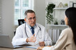 © Kannapat - Senior male doctor discussing health issues with patient.