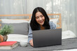 © edward_indy - Portrait of beautiful Asian woman lying on bed and using laptop computer at home. Enjoying free and Relax time, with happy moment. Communication Technology and social media concept