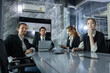 © eakgrungenerd - Group of professionals engaged in a brainstorming session at conference table in contemporary office. They are sharing ideas and reviewing data presentations for strategy planning.