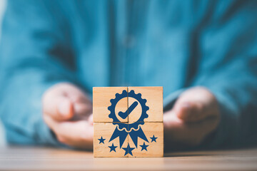 Fototapete - Businessman hand giving and showing the best quality assurance which print screen on wooden block cube with five stars for guarantee product and ISO service concept.