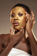 © fotofabrika - Woman applying a luxurious gold facial mask at a spa during a self-care session