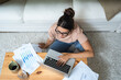 © Srdjan - Young woman freelance worker small startup company business owner calculating tax return with data on laptop computer. Working at home office, professional occupation female modern technology user.