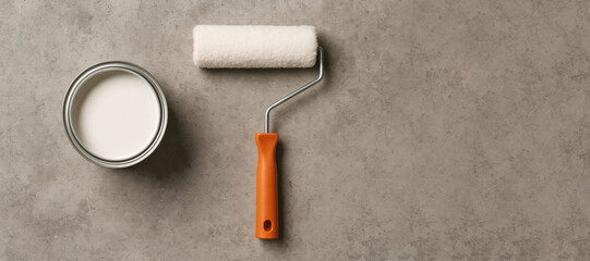 Poster - White Paint Can and Roller Resting on a Textured Surface Ready for Home Renovation Tasks in a Well-Lit Environment