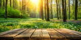 A rustic wooden table sits atop a lush green forest floor surrounded by tall trees with vibrant spring foliage and wildflowers