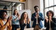 © Richafuji - Group of diverse business professionals clapping hands in an office setting celebrating success with smiles and positive emotions. Warm lighting and blurred background.
