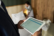 © pressmaster - Business person managing hotel staff using tablet technology for housekeeping operations in hotel room setting while focusing on digital data and lists of duties
