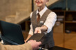 © pressmaster - Receptionist receiving passport from a guest at hotel front desk, maintaining a welcoming smile. The interaction signifies start of the check-in process