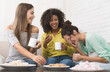 © Prostock-studio - Diverse roommates drinking coffee, eating cookies and laughing at home
