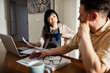 © Marko Geber - Couple discussing finances at home with laptop and bills on the table