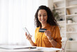 © Prostock-studio - Happy Arabic Female Shopping Online Using Cellphone Making Payment Via Mobile Banking App Sitting At Desk In Office. Internet Commerce And Consumerism Concept