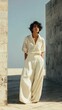 © kurosaki_D - A woman in a cream-colored linen shirt and wide-leg pants outdoors.