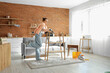 © Pixel-Shot - Young woman painting shelf unit in kitchen