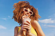 © SHOTPRIME STUDIO - Cheerful young woman enjoying a smoothie against a bright blue sky