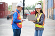 © offsuperphoto - Engineers or workers using laptop computer and talking about work in containers warehouse storage