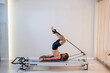 © Михаил Решетников - A man doing Pilates on a reformer.