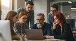 © Vita - Group of diverse colleagues gathered around a laptop, engaged in a meeting or brainstorming session